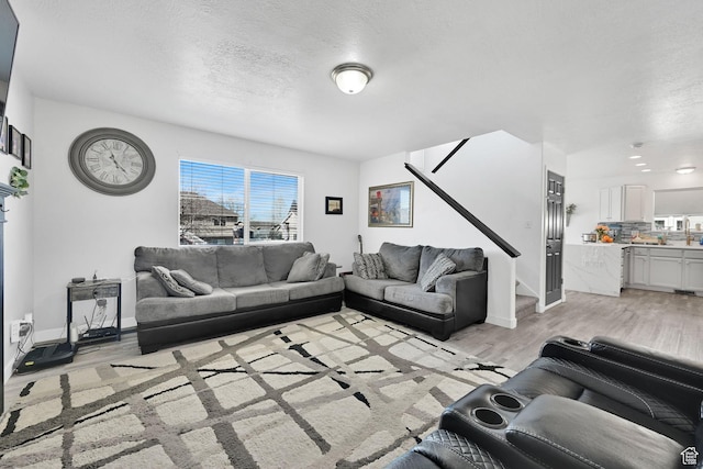 1087 N 1000 W, Clinton, UT 84015 - living room with light wood-style floors, baseboards, stairway, and a textured ceiling