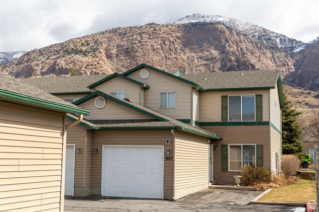 view of front of house featuring an attached garage, a mountain view, and driveway