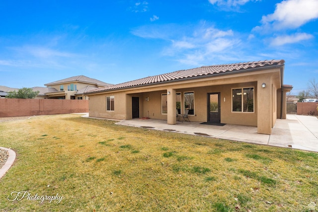 2275 E Rustic Dr, St George, UT 84790 - rear view of house featuring a yard, a patio, stucco siding, fence, and a tiled roof