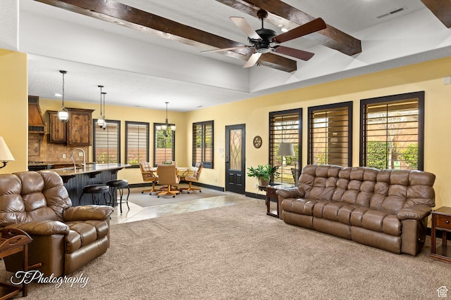 2275 E Rustic Dr, St George, UT 84790 - living room featuring light tile patterned floors, a wealth of natural light, beam ceiling, and light colored carpet
