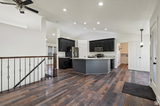 kitchen with vaulted ceiling, a ceiling fan, a sink, stainless steel appliances, and a center island with sink