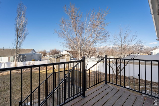 wooden terrace with a fenced backyard