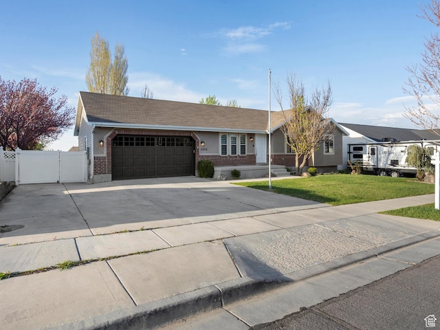 ranch-style house featuring fence, a front lawn, driveway, brick siding, and a garage
