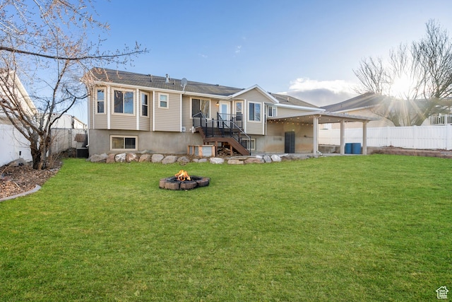 back of property featuring a lawn, a fenced backyard, and an outdoor fire pit