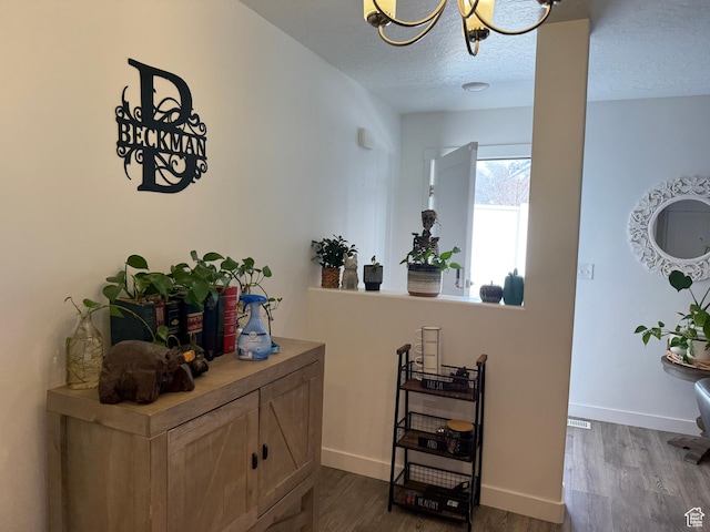 2810 N Fighting Falcon St, Layton, UT 84040 - hallway featuring dark wood-style flooring, baseboards, an inviting chandelier, and a textured ceiling