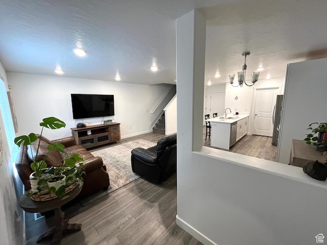 2810 N Fighting Falcon St, Layton, UT 84040 - living room with a chandelier, stairway, light wood-type flooring, and baseboards