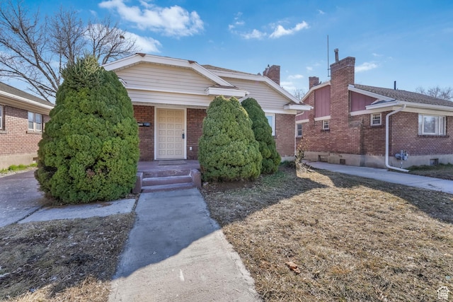 bungalow-style house with covered porch and brick siding