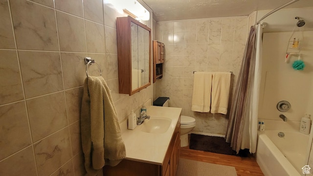 4142 S 3425 W, West Valley City, UT 84119 - bathroom featuring tile walls, wood finished floors, vanity, shower / bath combo with shower curtain, and toilet