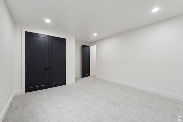 unfurnished bedroom with light carpet, baseboards, and recessed lighting