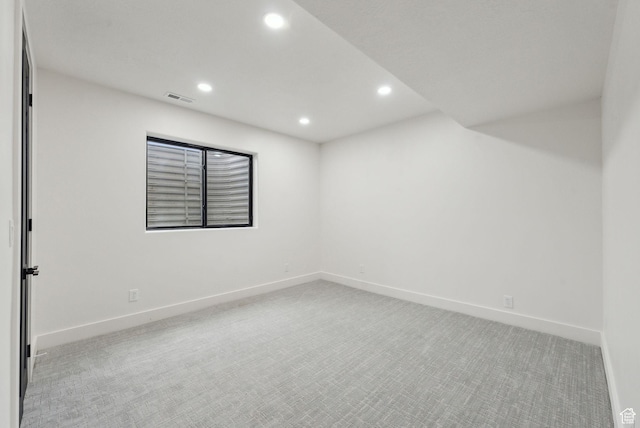 spare room with light colored carpet, visible vents, baseboards, and recessed lighting