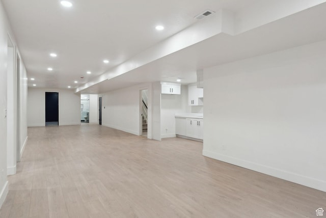 spare room featuring light wood-style flooring, recessed lighting, visible vents, baseboards, and stairway