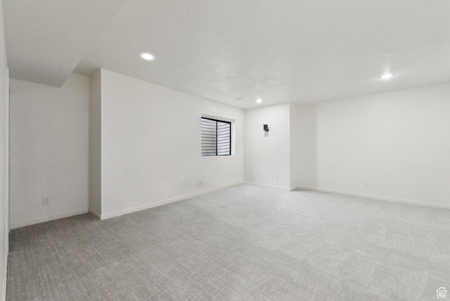 spare room featuring carpet floors, recessed lighting, and baseboards