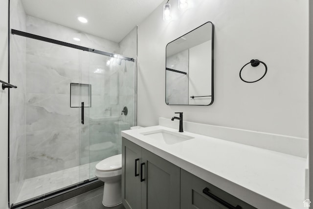 bathroom featuring a stall shower, vanity, toilet, and recessed lighting