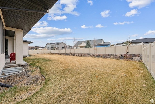 view of yard with a residential view and a fenced backyard
