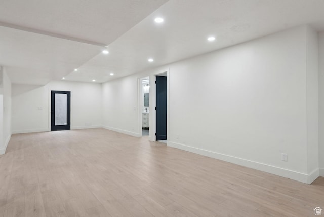 empty room with light wood-style floors, recessed lighting, and baseboards