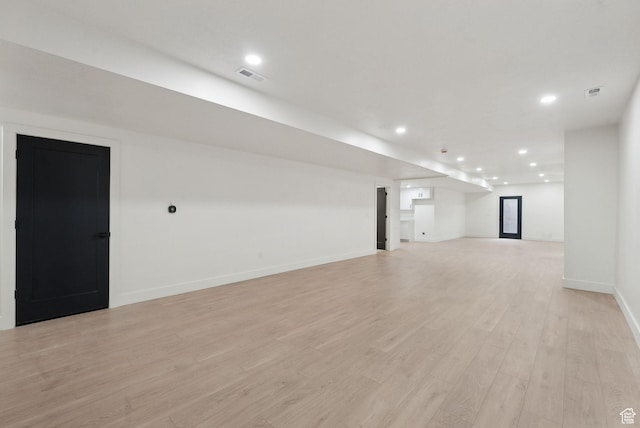 finished below grade area featuring recessed lighting, baseboards, visible vents, and light wood finished floors