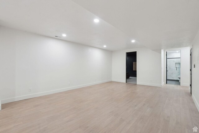 spare room featuring light wood-type flooring, visible vents, baseboards, and recessed lighting