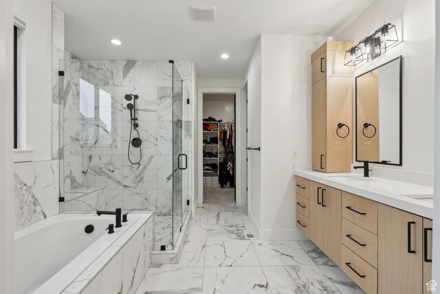bathroom with marble finish floor, a marble finish shower, a spacious closet, a sink, and a bath
