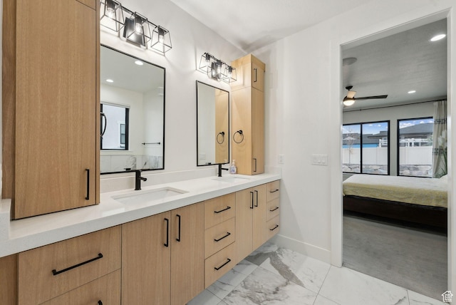 ensuite bathroom featuring connected bathroom, marble finish floor, a sink, and a ceiling fan