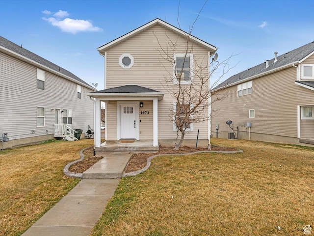traditional-style house with central AC unit and a front lawn