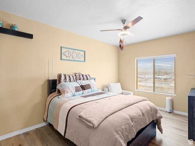 3478 S Cozy River Pl W Unit 203, West Valley City, UT 84119 - bedroom featuring wood finished floors, a ceiling fan, and baseboards