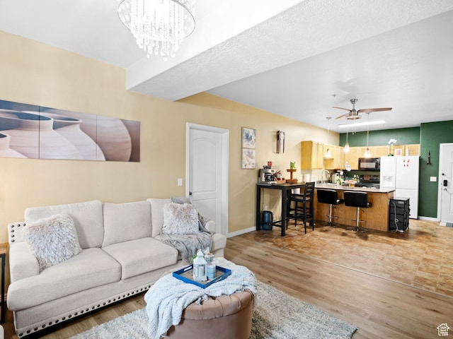 3478 S Cozy River Pl W Unit 203, West Valley City, UT 84119 - living area with ceiling fan with notable chandelier, light wood finished floors, and baseboards
