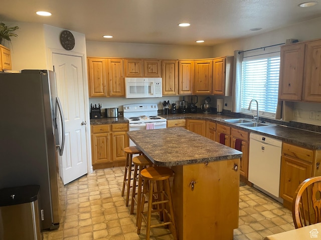 564 W 475 N, Clearfield, UT 84015 - kitchen featuring a sink, a kitchen bar, a kitchen island, white appliances, and dark countertops