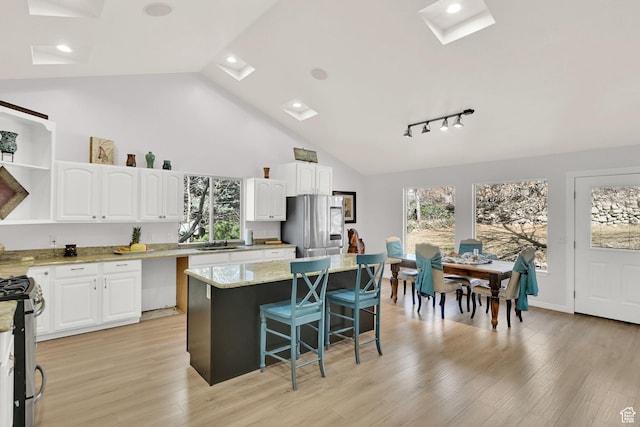654 E 3225 N, North Ogden, UT 84414 - kitchen with stainless steel appliances, white cabinetry, a breakfast bar area, and open shelves