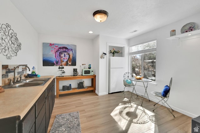 654 E 3225 N, North Ogden, UT 84414 - kitchen with light wood-type flooring, white appliances, light countertops, and a sink