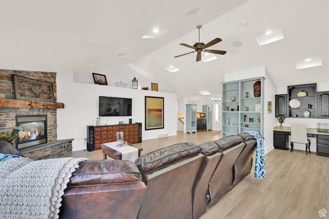 654 E 3225 N, North Ogden, UT 84414 - living room with lofted ceiling, ceiling fan, a stone fireplace, visible vents, and light wood-style floors