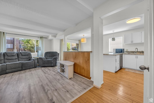 1384 Millcreek Dr Unit 6, Ogden, UT 84404 - living area with light wood finished floors, a wealth of natural light, and beam ceiling