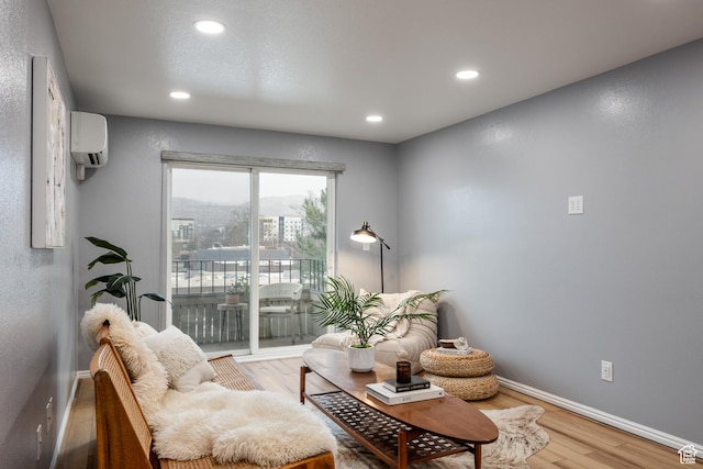 living area with wood finished floors, recessed lighting, baseboards, and a wall unit AC