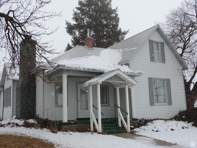 view of front of house featuring metal roof and a chimney