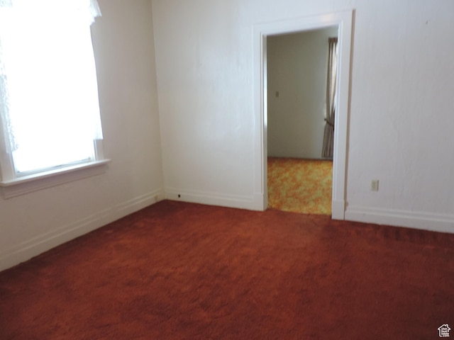 empty room with carpet and baseboards