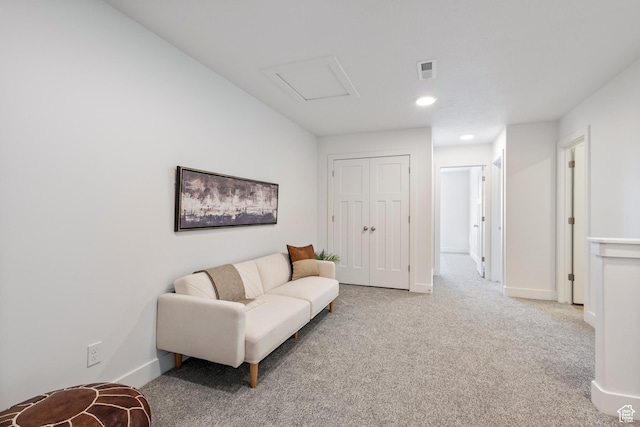 living area with baseboards, carpet floors, visible vents, and attic access