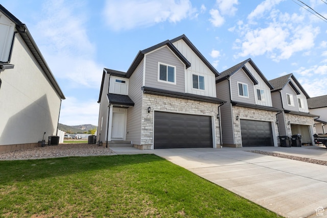view of front of property with board and batten siding, a front yard, concrete driveway, and central air condition unit