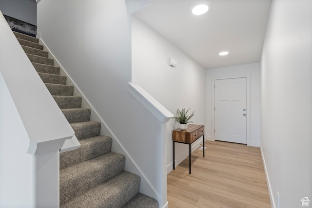 stairs featuring recessed lighting, wood finished floors, and baseboards