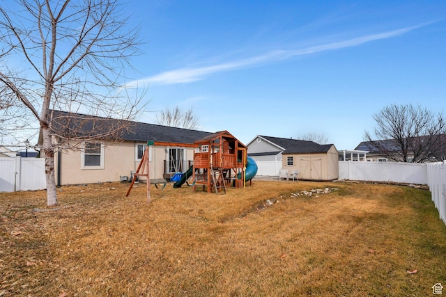 75 E Redwing Ct, Saratoga Springs, UT 84045 - rear view of house featuring an outbuilding, a fenced backyard, a lawn, stucco siding, and a storage unit