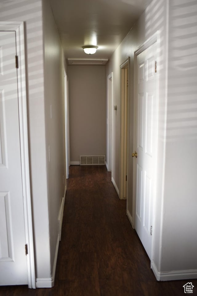 hallway with visible vents and baseboards