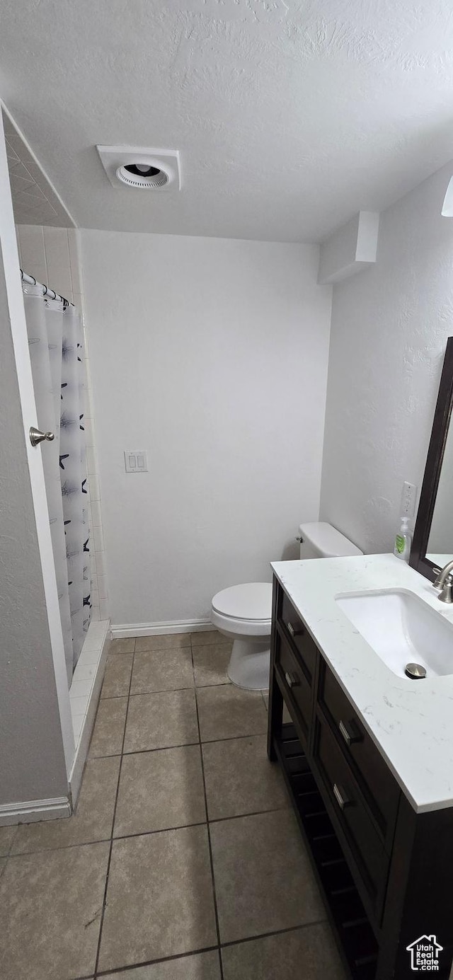 bathroom with a textured ceiling, a shower stall, toilet, and vanity