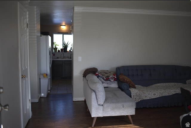living room with dark wood-type flooring, crown molding, and baseboards