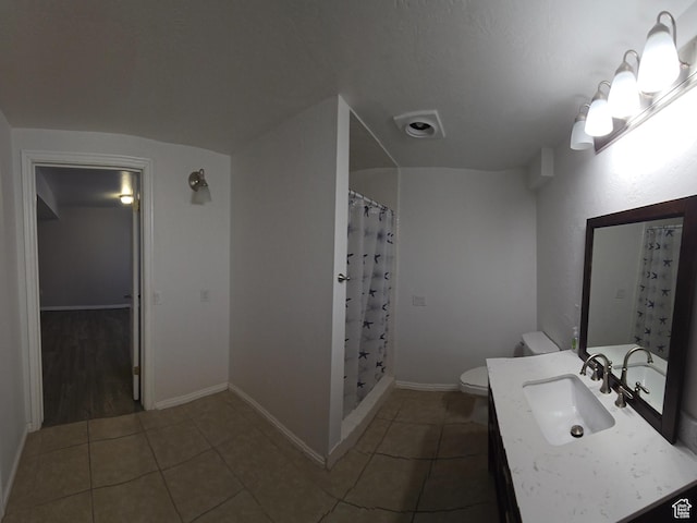 bathroom with toilet, a shower with curtain, tile patterned flooring, and vanity