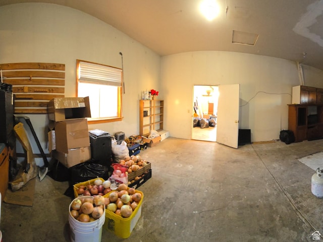 miscellaneous room with concrete flooring and vaulted ceiling