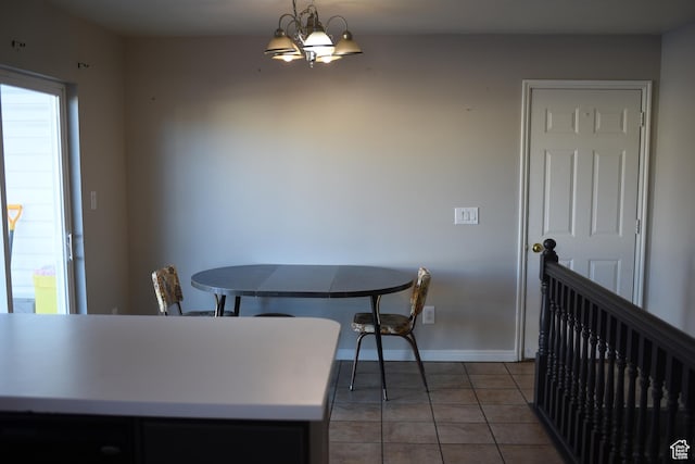 dining area with a notable chandelier, baseboards, and tile patterned floors