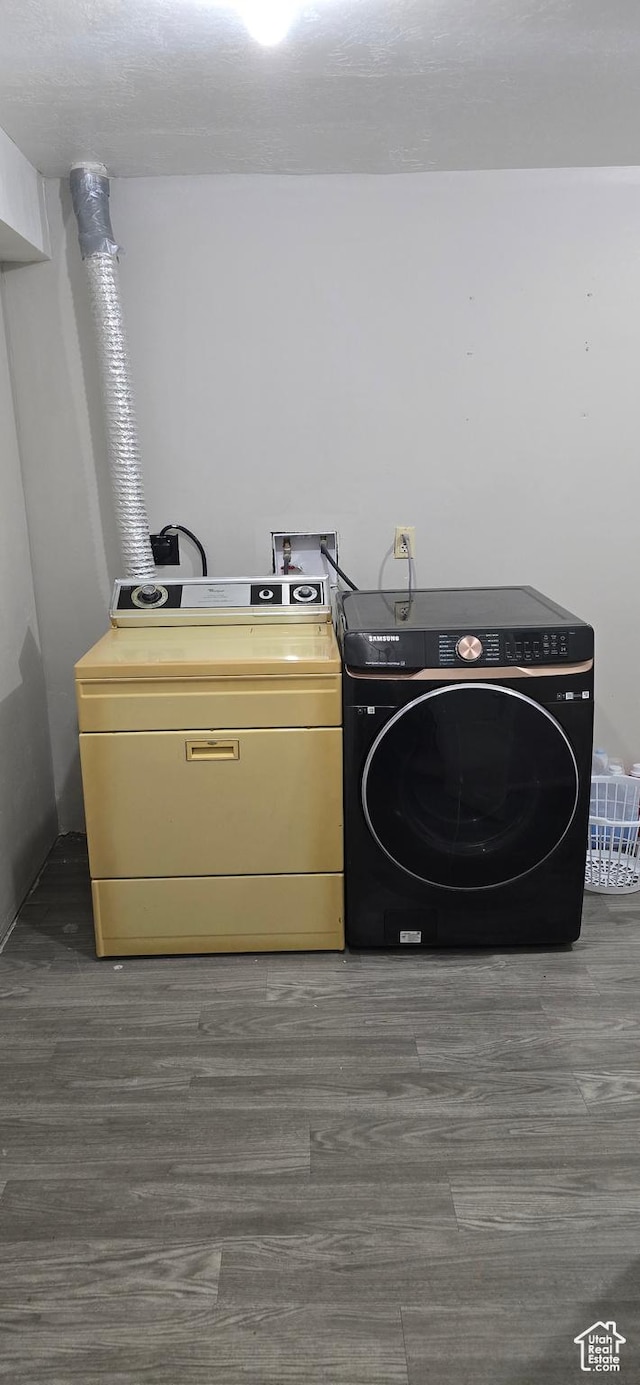laundry room with laundry area, washer and clothes dryer, and wood finished floors