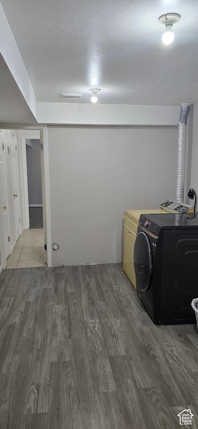 laundry area featuring laundry area, visible vents, washing machine and clothes dryer, and wood finished floors