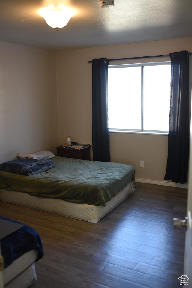 bedroom with baseboards and wood finished floors