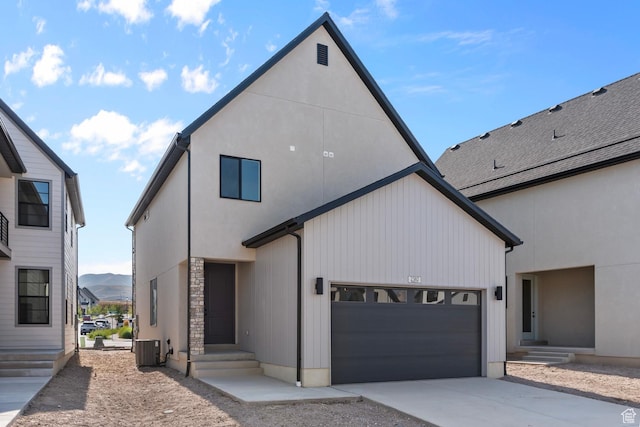view of front facade featuring an attached garage, stone siding, cooling unit, and concrete driveway