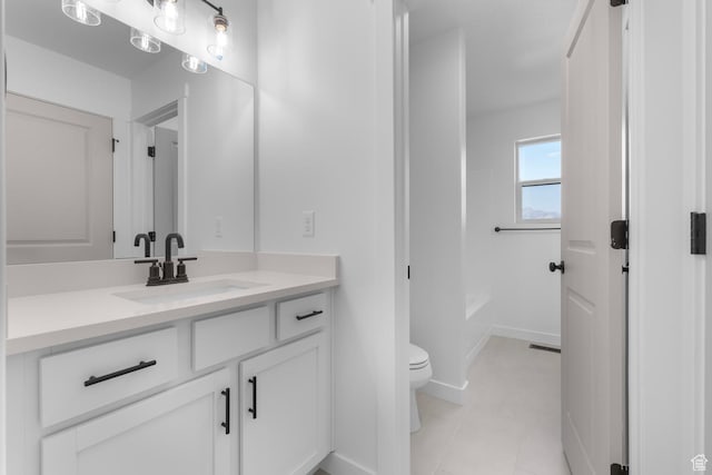 full bath featuring a washtub, toilet, vanity, tile patterned flooring, and baseboards