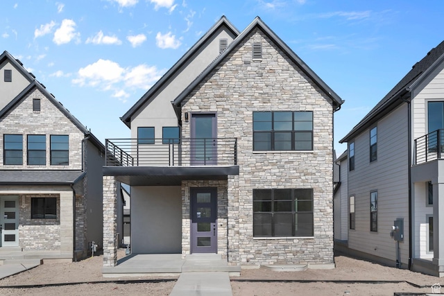 view of front of house with a balcony and stucco siding